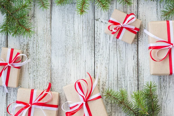 Confine di scatole regalo di Natale e ramo di abete su tavolo di legno . — Foto Stock