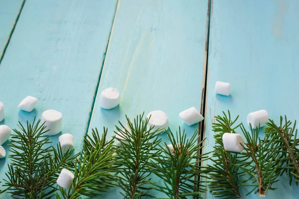 Çam ağacı ve ahşap arka plan üzerinde marshmallows dalı ile Noel sınır