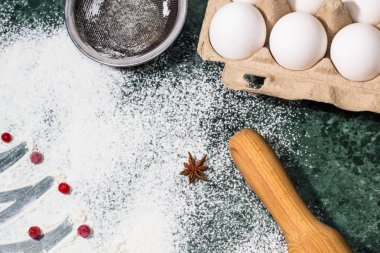 bir dekorasyon ve oklava, yumurta, süzgeç olarak un, çilek ve anason yıldızlı baharat