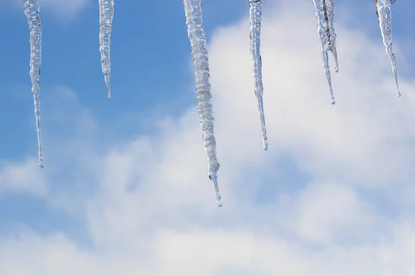 Icicles colgando en el techo en invierno. Formación de hielo natural de cristales de hielo que cuelgan en el borde del techo en invierno —  Fotos de Stock