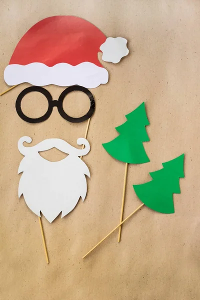 Foto estande adereços coloridos para a festa de Natal bigode, santa claus, abeto, óculos, chapéu — Fotografia de Stock