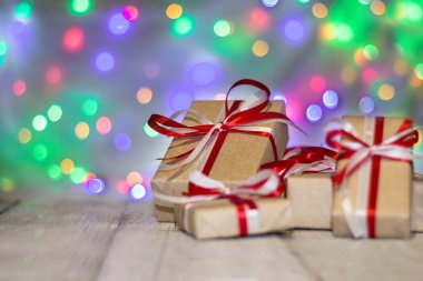 Noel hediye kutusu bokeh arka plana dayanır. Tatil tebrik kartı