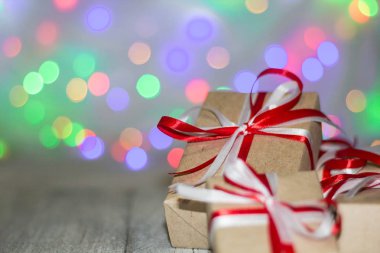 Noel hediye kutusu bokeh arka plana dayanır. Tatil tebrik kartı
