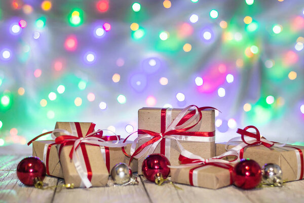 Christmas gift box with balls against bokeh background. Holiday greeting card