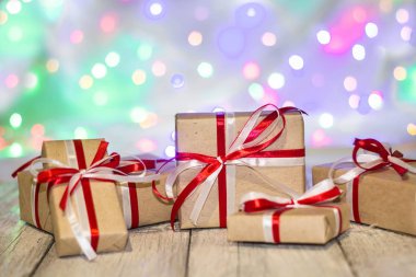 Noel hediye kutusu bokeh arka plana dayanır. Tatil tebrik kartı