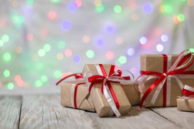 Noel hediye kutusu bokeh arka plana dayanır. Tatil tebrik kartı
