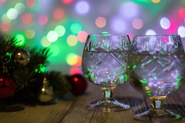 Two glasses of christmas champagne with christmas tree decorated of red and silver balls against light bokeh background — Stock Photo, Image