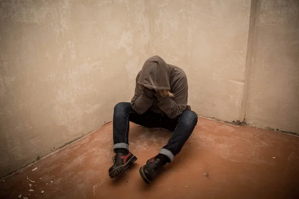Portret van man verdrietig, drugs verslaafde man zittend op de vloer in de hoek — Stockfoto