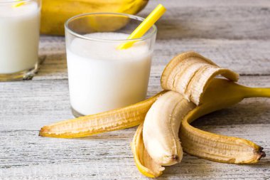 Ahşap arka plan üzerinde muz kokteyli ve taze muz