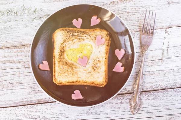 Desayuno para la celebración del día de San Valentín con salchichas y huevos en forma de corazón de pan — Foto de Stock