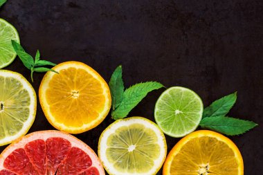 siyah köşede dilim portakal, limon, limon, greyfurt ve nane model ile. Düz yatıyordu