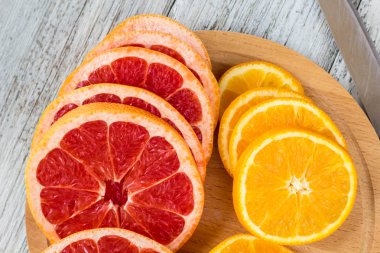 Dilimlenmiş portakal ve limon bir ahşap tahta ve bıçak.