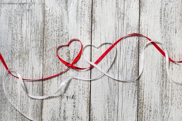 Red and white ribbon hearts for valentines day on wooden background Stock Picture