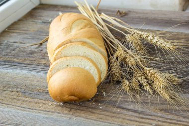 Ahşap masa portre üzerinde ekmek buğday dikenli dilimlenmiş.