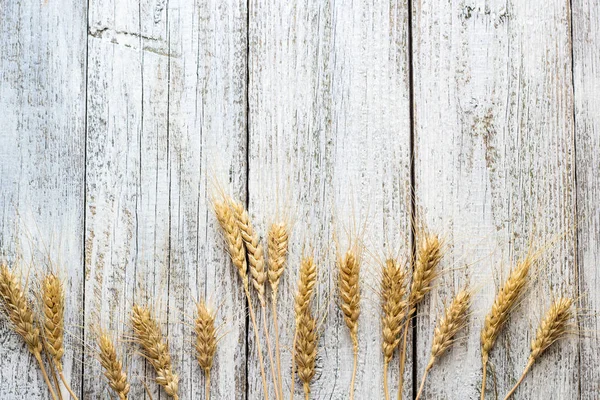Buğday beyaz eski ahşap masa arka planda spikelets.
