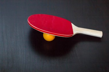 Masa Tenisi veya ping pong raket ve top siyah bir zemin üzerine