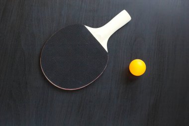 Masa Tenisi veya ping pong raket ve top siyah bir zemin üzerine