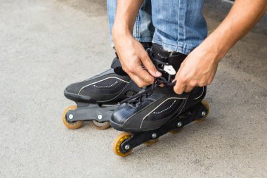 Adam adam tekerlekli paten üzerinde açık koyarak closeup