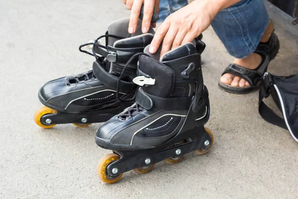 Closeup of man guy putting on roller skates outdoor — Stock Photo, Image