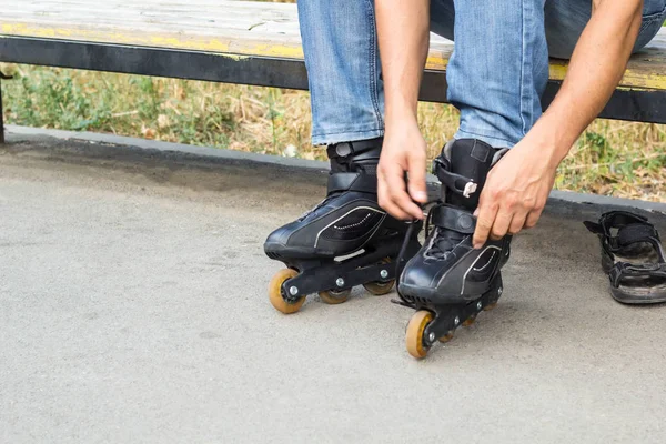 Fechar-se de homem cara colocando em patins ao ar livre — Fotografia de Stock