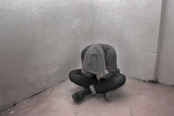 Zdjęcie z desperate młodego narkomana sobie kaptur i siedzi sama w rogu — Zdjęcie stockowe