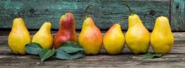 Afiş karanlık rustik ahşap masa yapraklarda ile taze armut.