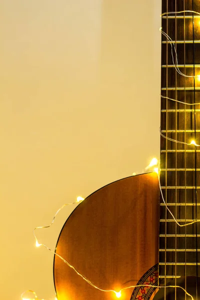 Violão envolto em uma grinalda luminosa. Presente de Natal — Fotografia de Stock