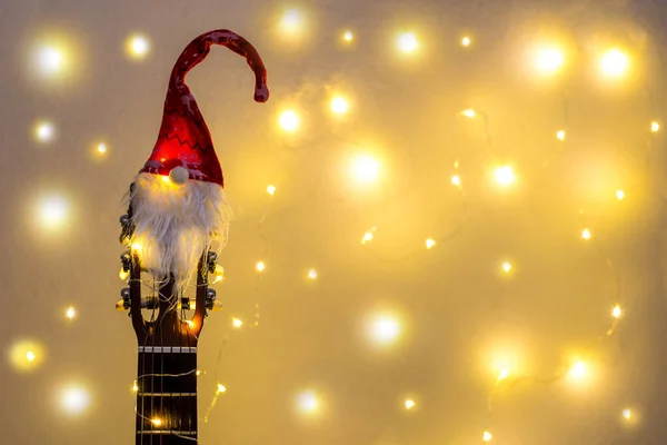 Akustisk gitarr med röd tomte hatt och lätt krans. Julmusik sångkoncept med copyspace — Stockfoto