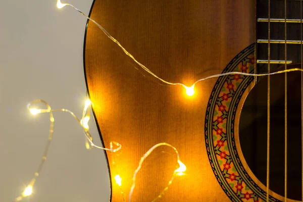 밝은 갈랜드에 싸여 있는 음향 기타. 크리스마스 선물 — 스톡 사진