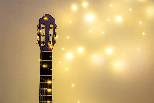 Akusztikus gitár fényes koszorúba csomagolva. Karácsonyi ajándék — Stock Fotó