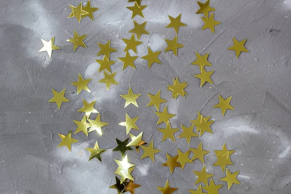 Золоті зірки конфетті на сірому фоні . — стокове фото