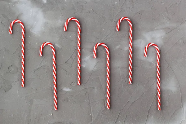Bordo di bastoncini di zucchero rosso e bianco su sfondo grigio. Concerto di Natale — Foto Stock