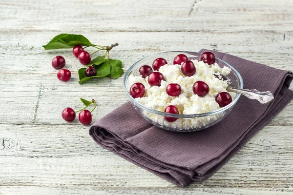 Colazione da ricotta con ciliegia in ciotola trasparente su sfondo bianco in legno — Foto Stock