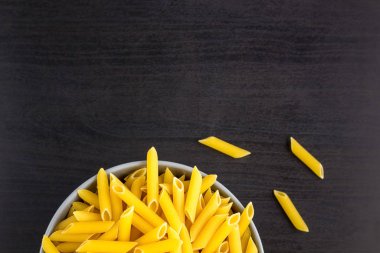 İtalyan çiğ makarnasıyla siyah arkaplan manzarası ya da fotokopi alanı olan makarna.