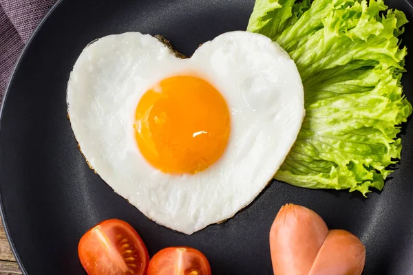 Gri tabakta servis edilen kalp şeklinde sahanda yumurtalarla Sevgililer Günü kahvaltısı. — Stok fotoğraf