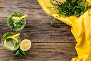 Lemonade or mojito cocktail with lemon and mint with ice. Cold summer refreshing drink decorated with yellow napkin