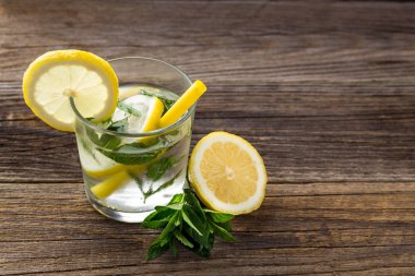 Ahşap zemin üzerinde limonlu ve naneli su. Yaz taze limonata içeceği