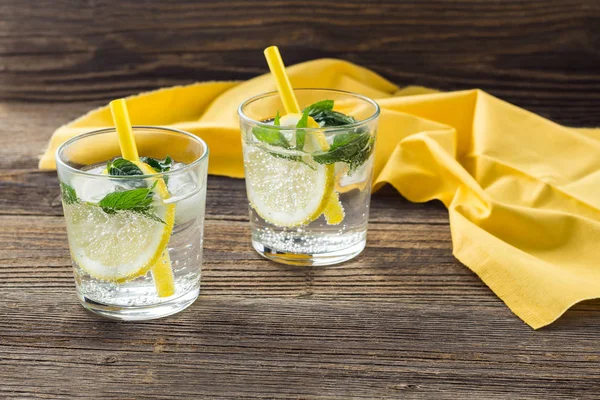 Cóctel de limonada o mojito con limón y menta con hielo. Bebida refrescante fría del verano decorada con servilleta amarilla — Foto de Stock