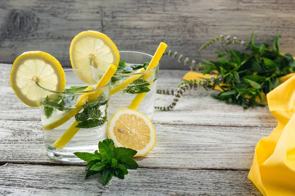 Lemonade or mojito cocktail with lemon and mint with ice. Cold summer refreshing drink decorated with yellow napkin — Stock Fotó