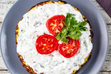 Domatesli kabak keki ve beyaz ahşap arka planda taze maydanoz. Peçeteli üst görünüm