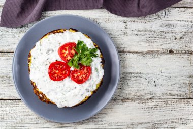 Domatesli kabak keki ve beyaz ahşap arka planda taze maydanoz. Peçeteli üst görünüm