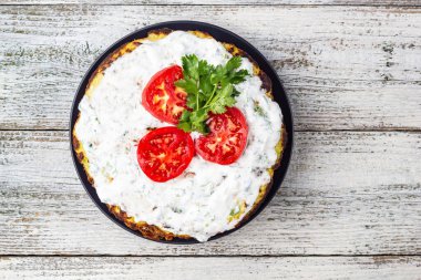 Domatesli kabak keki ve beyaz ahşap arka planda taze maydanoz. Üst görünüm