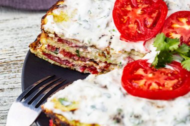 Domatesli kabak keki ve beyaz ahşap arka planda taze maydanoz. Peçete ve çatalla