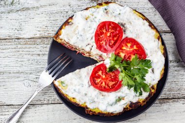 Domatesli kabak keki ve beyaz ahşap arka planda taze maydanoz. Peçete ve çatalla