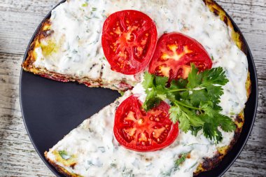 Domatesli kabak keki ve beyaz ahşap arka planda taze maydanoz. Üst görünüm