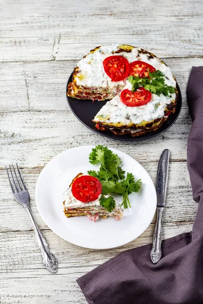 西葫芦蛋糕 西红柿和新鲜的欧芹 白色木制背景 用餐巾叉子和刀 — 图库照片