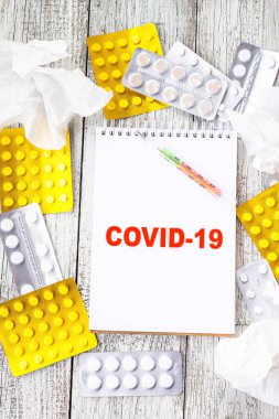 Coronavirus 'u tıbbi ilaçlar ve tabletlerle dolu bir arkaplanda not defterine yaz. Romantik Coronavirus 2019-nov