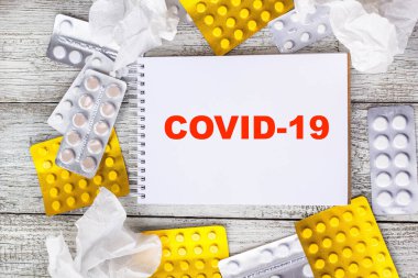Coronavirus 'u tıbbi ilaçlar ve tabletlerle dolu bir arkaplanda not defterine yaz. Romantik Coronavirus 2019-nov