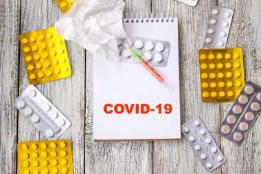 Coronavirus 'u tıbbi ilaçlar ve tabletlerle dolu bir arkaplanda not defterine yaz. Romantik Coronavirus 2019-nov