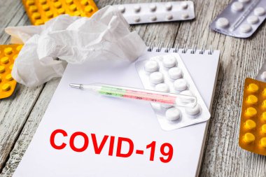 Coronavirus 'u tıbbi ilaçlar ve tabletlerle dolu bir arkaplanda not defterine yaz. Romantik Coronavirus 2019-nov